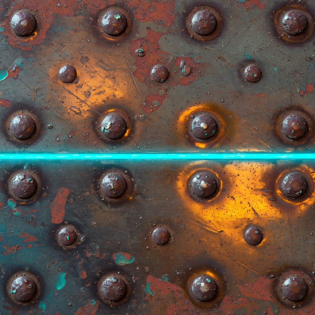 Weathered riveted steel plate crossed by a thin cyan LED line.